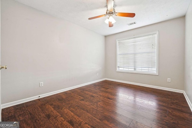 spare room featuring visible vents, ceiling fan, a textured ceiling, wood finished floors, and baseboards