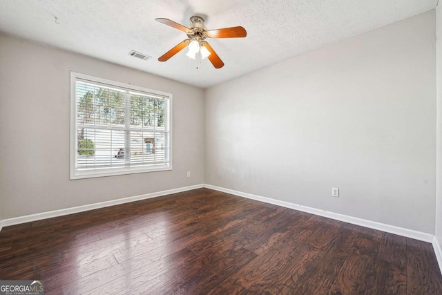 spare room featuring dark wood-style floors, baseboards, and a textured ceiling