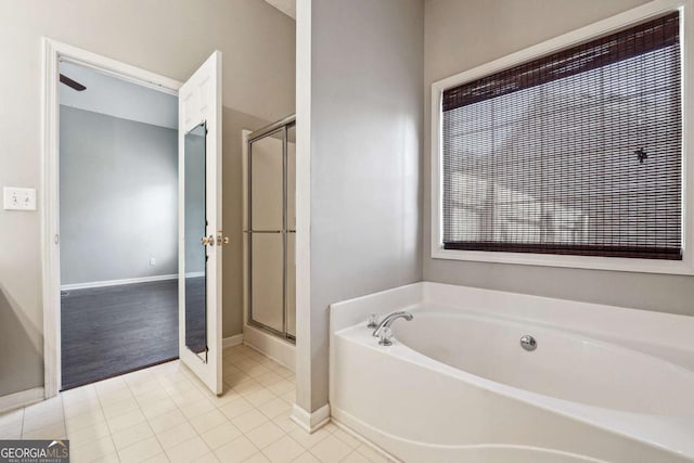 full bathroom with a stall shower, tile patterned flooring, baseboards, and a bath