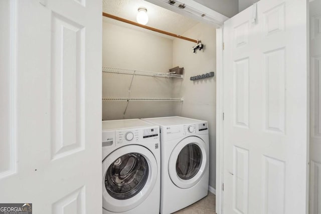 clothes washing area with laundry area, light tile patterned floors, and independent washer and dryer