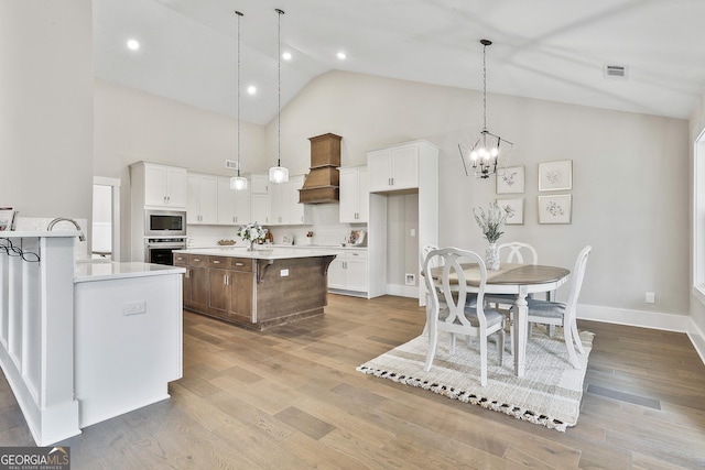 kitchen featuring visible vents, white cabinets, appliances with stainless steel finishes, wood finished floors, and light countertops