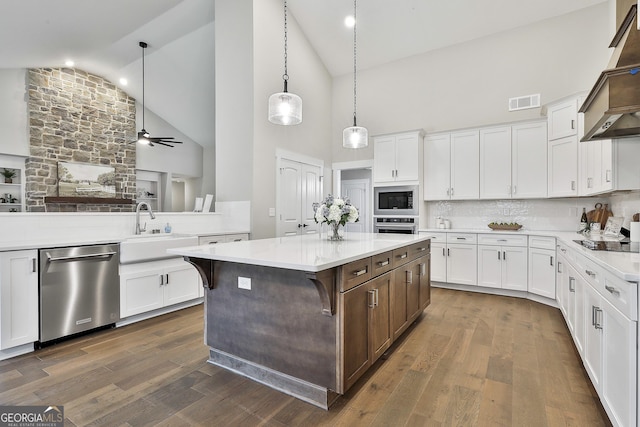 kitchen with light countertops, appliances with stainless steel finishes, dark wood-type flooring, and a sink