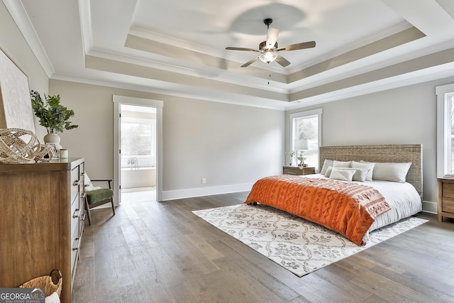 bedroom featuring crown molding, a tray ceiling, and dark wood finished floors