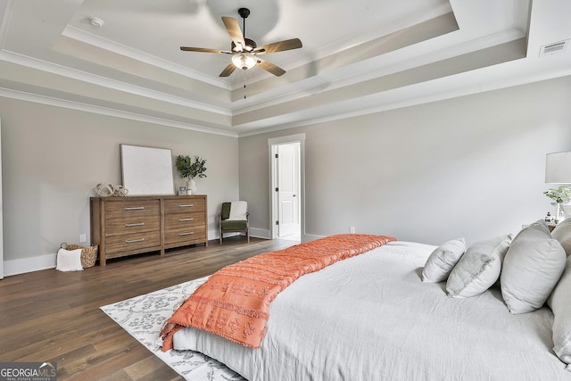 bedroom with baseboards, visible vents, a raised ceiling, and dark wood-style flooring