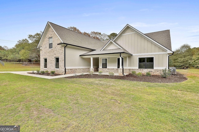 view of front of house with brick siding, a front lawn, and board and batten siding