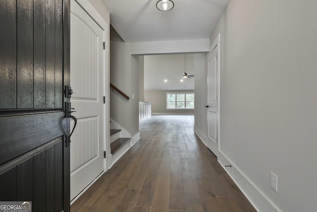 entrance foyer featuring stairs, dark wood-type flooring, and baseboards