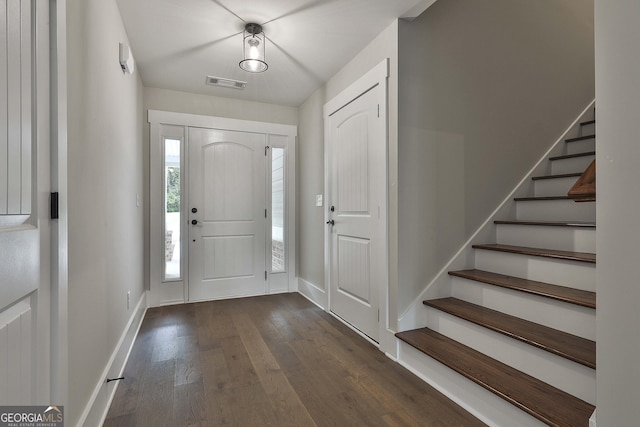 foyer featuring baseboards, stairs, visible vents, and hardwood / wood-style floors