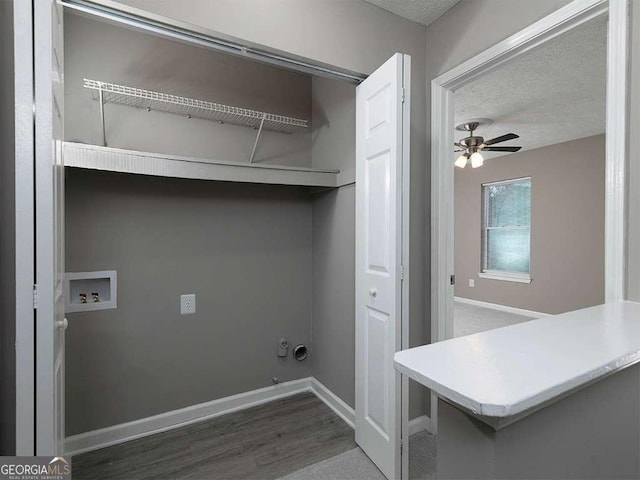 laundry area with hookup for a washing machine, a ceiling fan, wood finished floors, laundry area, and baseboards