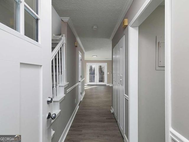 corridor featuring ornamental molding, dark wood-style flooring, stairs, a textured ceiling, and french doors