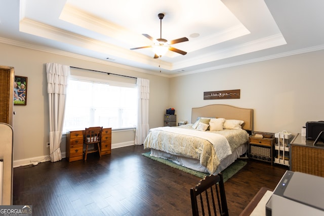 bedroom with wood finished floors, a ceiling fan, baseboards, a raised ceiling, and crown molding