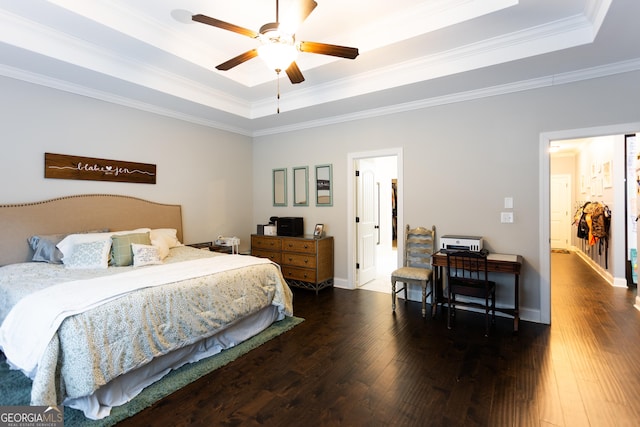 bedroom with ornamental molding, a raised ceiling, hardwood / wood-style flooring, and baseboards