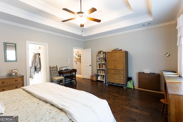 bedroom featuring a tray ceiling, dark wood finished floors, visible vents, ornamental molding, and ceiling fan