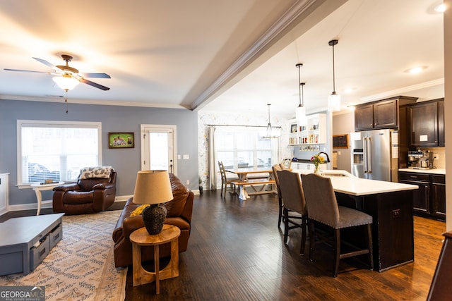 kitchen featuring dark brown cabinetry, high end refrigerator, a sink, light countertops, and crown molding