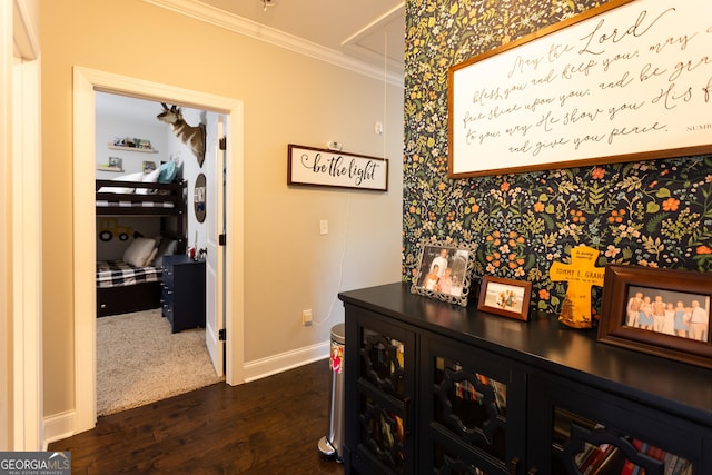 hallway featuring attic access, baseboards, dark wood-type flooring, and crown molding