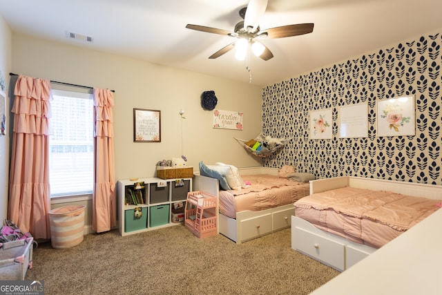 bedroom with carpet flooring, visible vents, and a ceiling fan