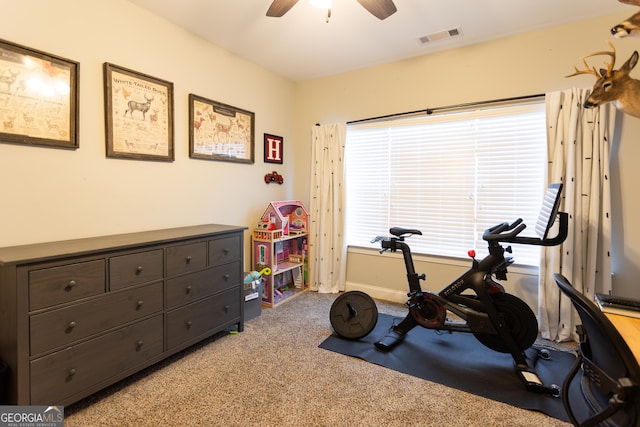 workout room with visible vents, a ceiling fan, and light colored carpet