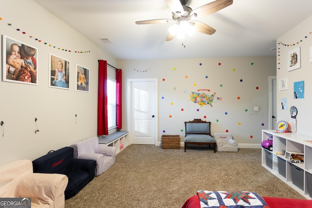 recreation room featuring a ceiling fan, carpet, visible vents, and baseboards