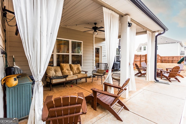 view of patio / terrace with ceiling fan, fence, and an outdoor living space with a fire pit