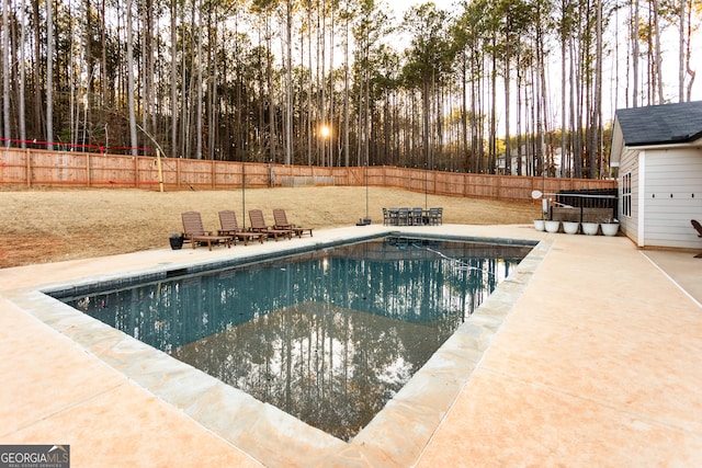 view of swimming pool featuring a patio area, a fenced backyard, and a fenced in pool