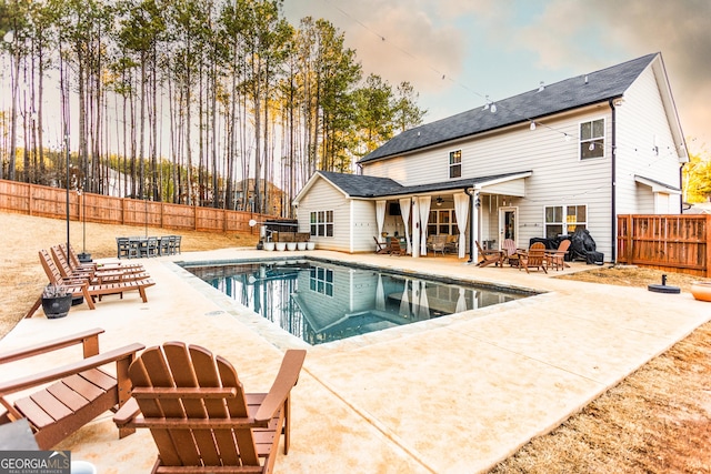 view of swimming pool with a fenced backyard, a fenced in pool, and a patio