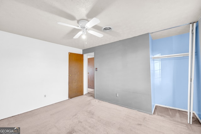 unfurnished bedroom with visible vents, a ceiling fan, a textured ceiling, a closet, and carpet flooring