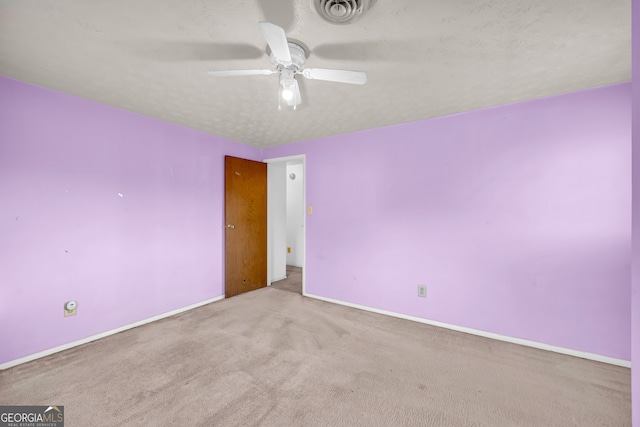 empty room featuring visible vents, baseboards, carpet flooring, a textured ceiling, and a ceiling fan