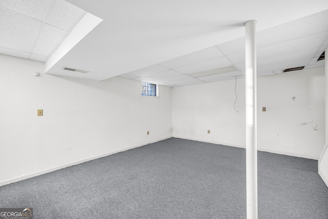 basement featuring visible vents, a paneled ceiling, baseboards, and carpet floors