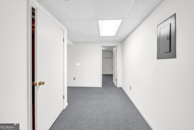 interior space featuring carpet flooring, electric panel, baseboards, and a drop ceiling