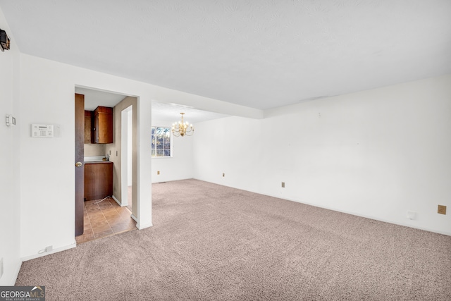 unfurnished living room featuring light carpet and a chandelier