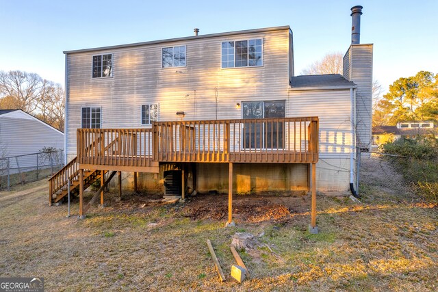 rear view of house with a deck, stairs, fence, and a chimney