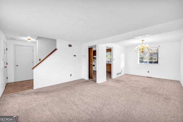 unfurnished living room featuring visible vents, carpet, and a notable chandelier