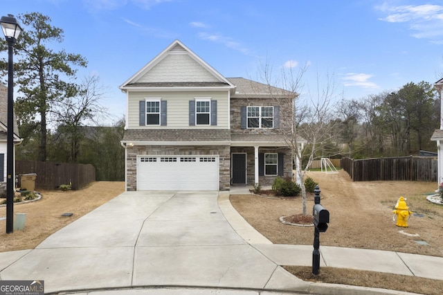 view of front facade with stone siding, driveway, an attached garage, and fence