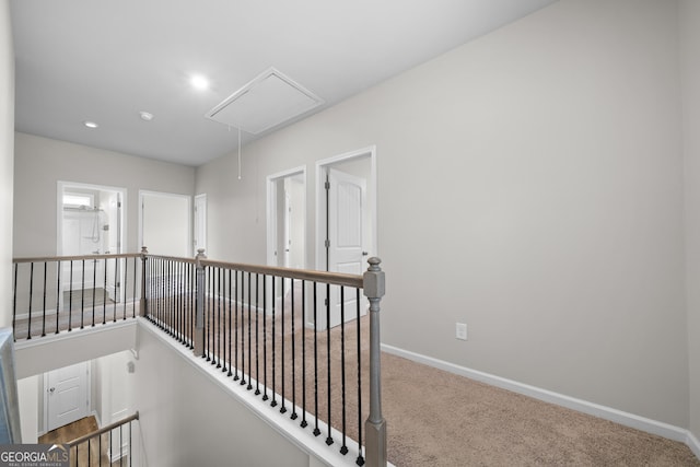 hall with carpet floors, recessed lighting, attic access, an upstairs landing, and baseboards