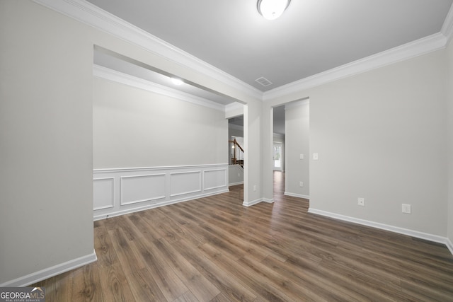 spare room featuring stairway, wood finished floors, visible vents, and crown molding