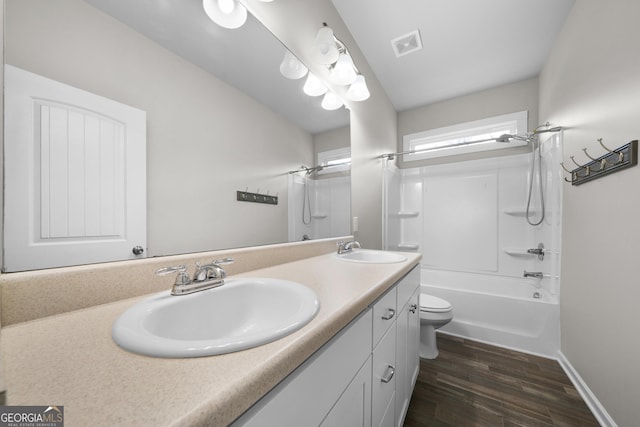 full bath featuring double vanity, visible vents, a sink, and wood finished floors
