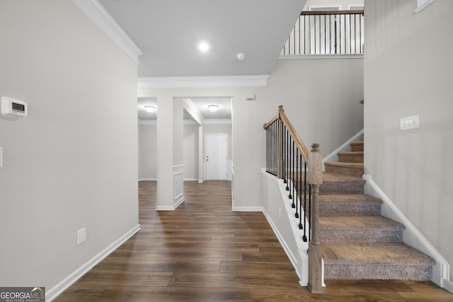 stairs featuring ornamental molding, baseboards, and wood finished floors