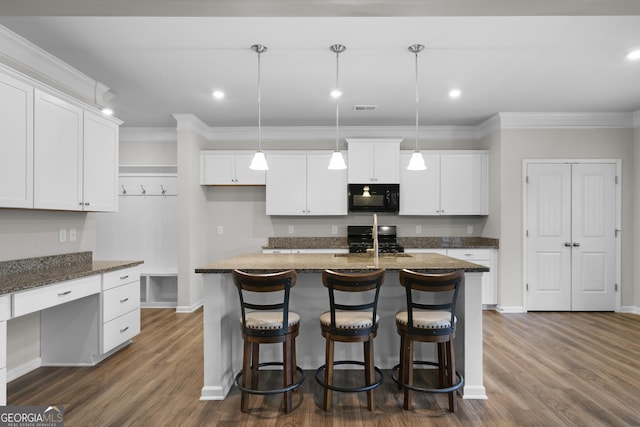 kitchen with dark wood finished floors, black microwave, crown molding, and gas range