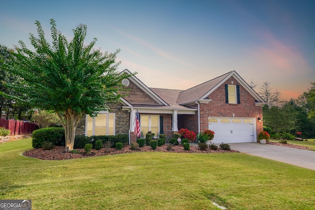 craftsman inspired home with a garage, brick siding, driveway, stone siding, and a front yard