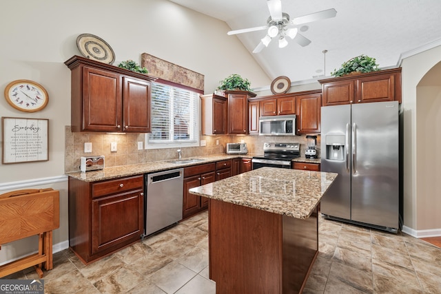 kitchen featuring a kitchen island, appliances with stainless steel finishes, backsplash, and light stone counters