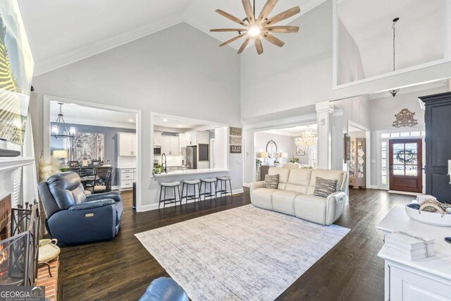 living room with dark wood-style floors, a fireplace, lofted ceiling, baseboards, and ceiling fan with notable chandelier