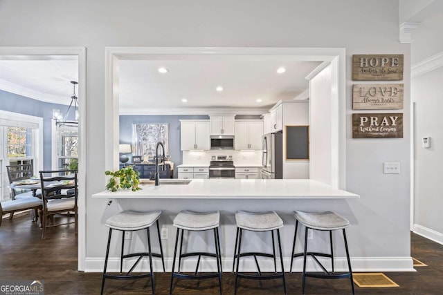 kitchen with a peninsula, a breakfast bar area, stainless steel appliances, and a sink