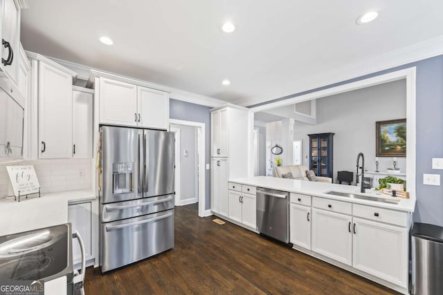 kitchen with light countertops, appliances with stainless steel finishes, a sink, and white cabinets