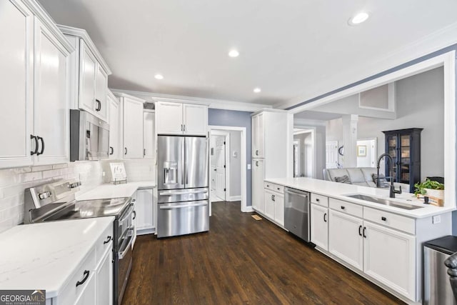 kitchen with a sink, white cabinetry, appliances with stainless steel finishes, tasteful backsplash, and dark wood finished floors