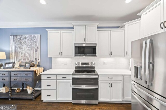 kitchen with stainless steel appliances, light countertops, decorative backsplash, ornamental molding, and white cabinetry