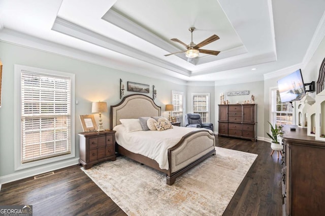 bedroom featuring a raised ceiling, multiple windows, and visible vents