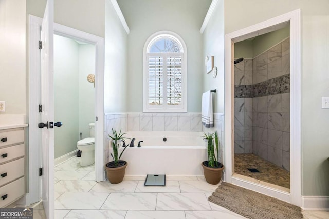 bathroom featuring toilet, marble finish floor, a shower stall, and a bath