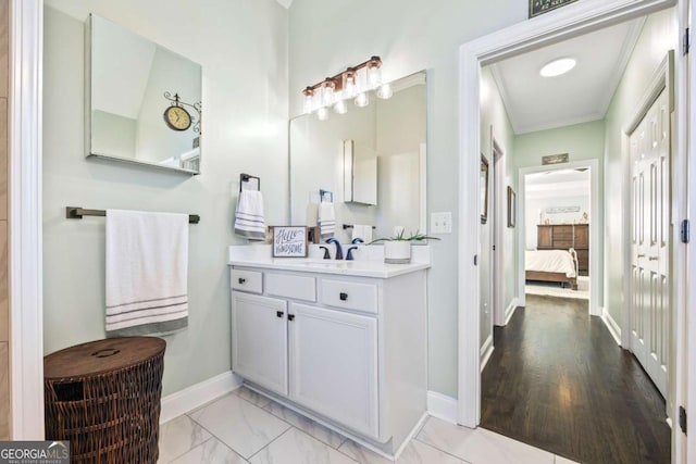 ensuite bathroom featuring marble finish floor, crown molding, connected bathroom, vanity, and baseboards