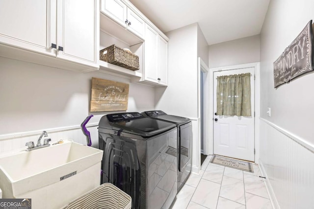 laundry area with a sink, marble finish floor, wainscoting, cabinet space, and washing machine and clothes dryer