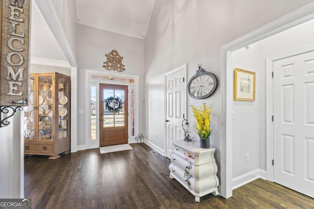 foyer entrance with high vaulted ceiling, ornamental molding, wood finished floors, and baseboards