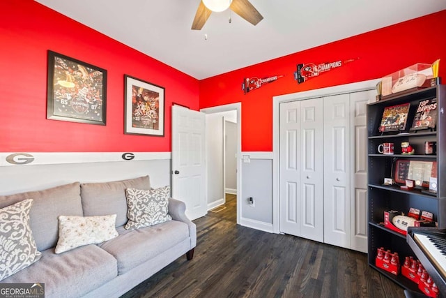 living room with a ceiling fan, baseboards, and wood finished floors